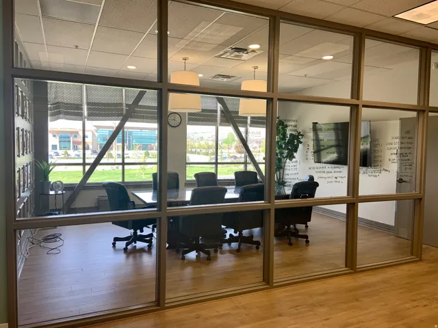 Conference room featuring full-height glass partitions and wood-finish flooring