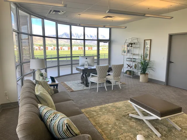 Spacious interior featuring a curved wall of full-height windows, presenting abundant natural light and exterior landscape