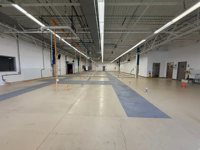 Spacious commercial interior featuring high ceilings and exposed structural elements