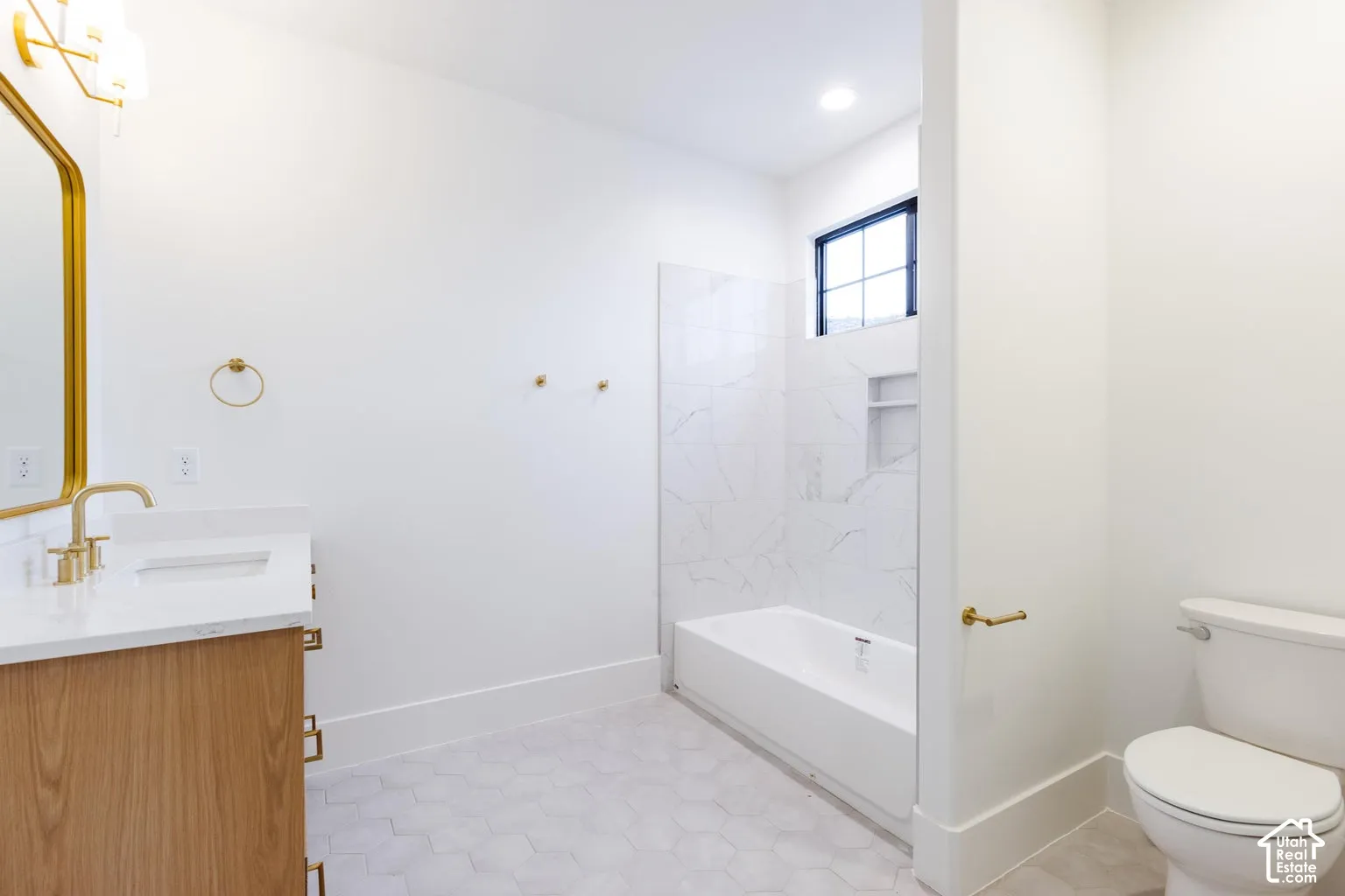 Bathroom featuring a wood-finish vanity with a white countertop and gold-tone fixtures