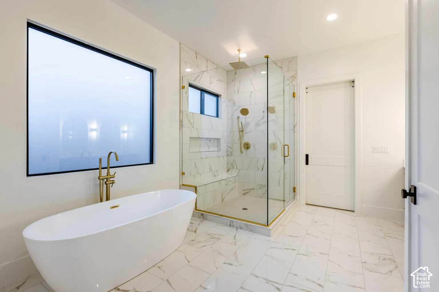 Freestanding soaking tub with floor-mounted brass faucet