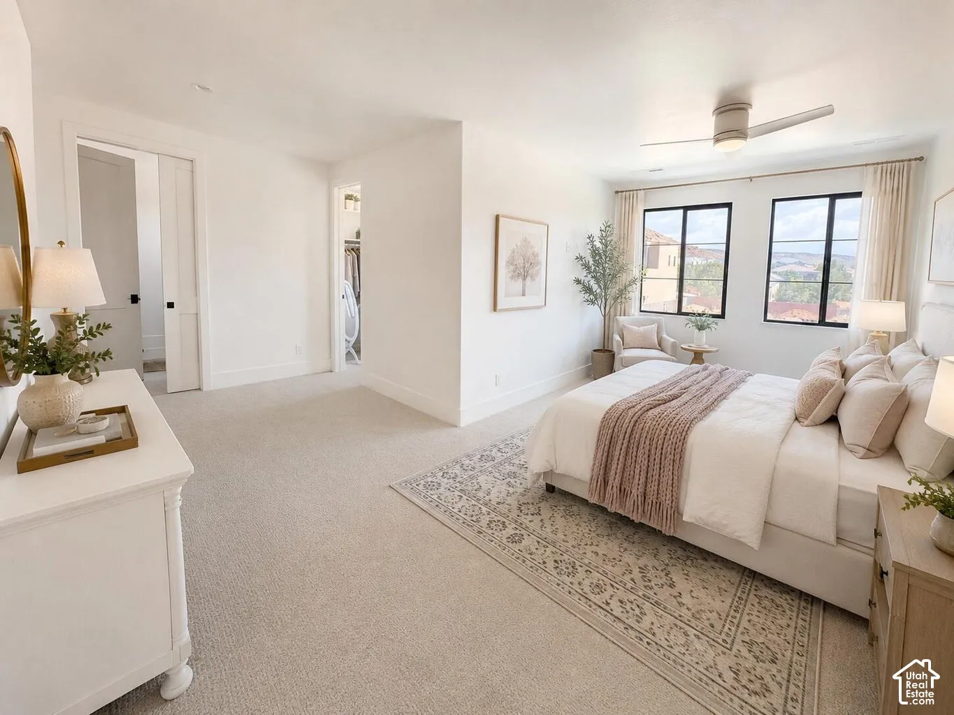 Light-filled interior space with expansive windows, a ceiling fan, and plush carpet flooring