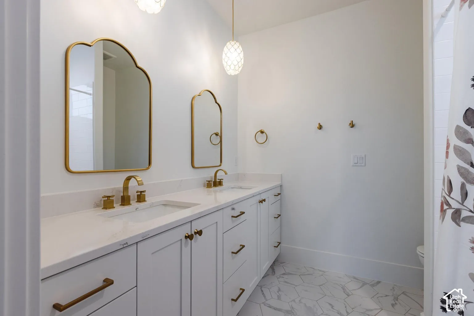 Dual vanity with undermount sinks and brass-finish hardware