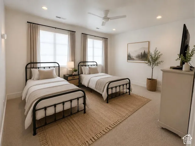Spacious room featuring two large windows, recessed ceiling lighting, a ceiling fan, and light-toned carpeting