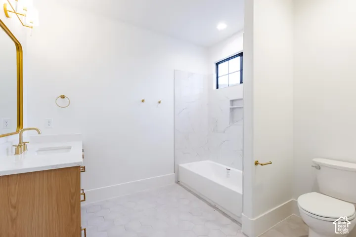 Bathroom featuring a wood-finish vanity with a white countertop and gold-tone fixtures