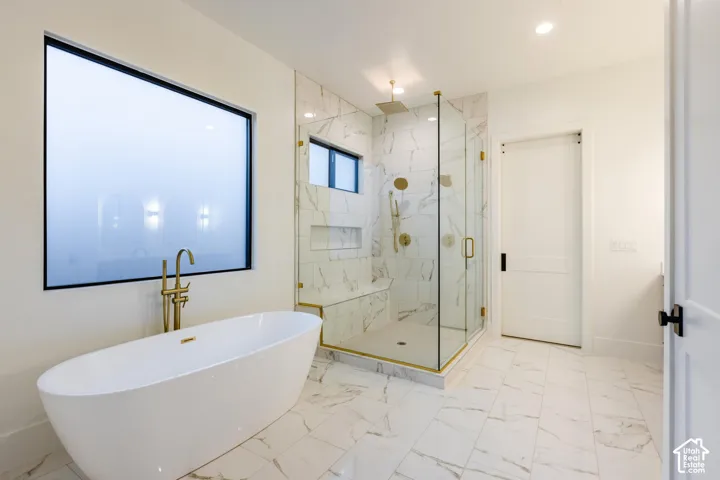 Freestanding soaking tub with floor-mounted brass faucet