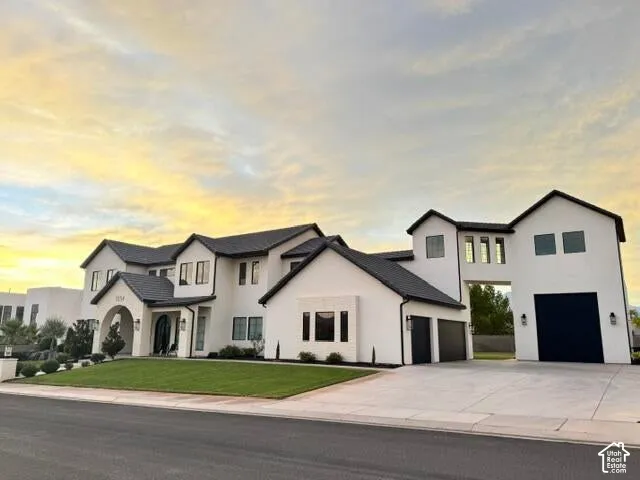 Contemporary residence featuring a white stucco exterior and dark-tiled roofing