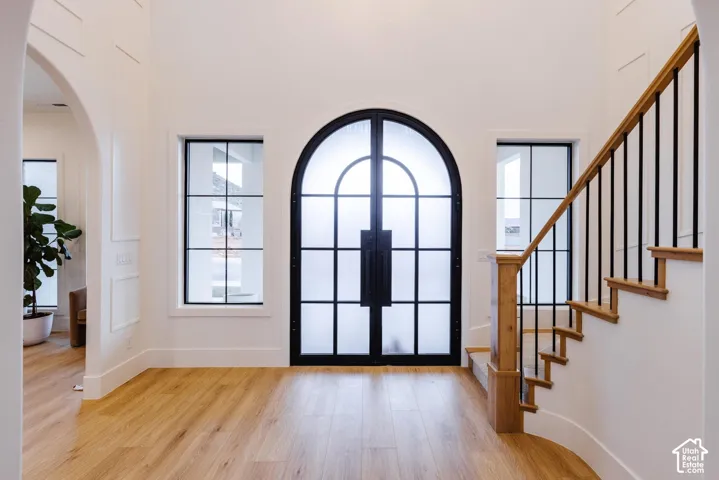 Grand entry featuring an arched double door with frosted glass and black grid detailing