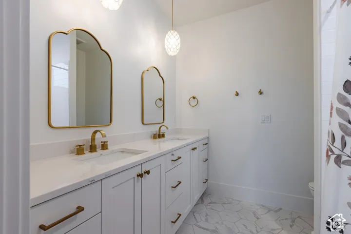 Dual vanity with undermount sinks and brass-finish hardware