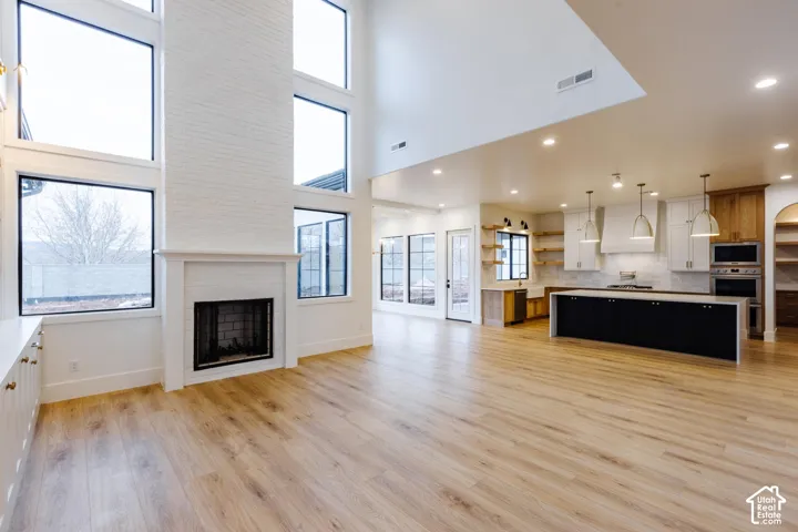 Expansive open-concept living space with light wood-finish flooring
