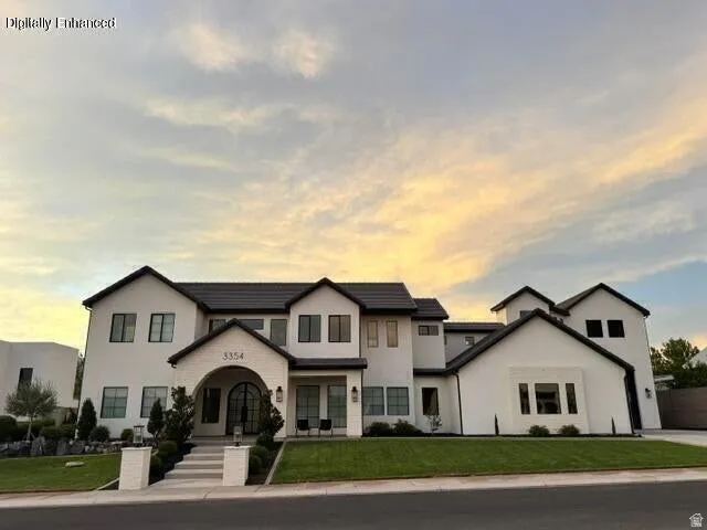 Modern architectural facade featuring a white stucco exterior with dark trim and a multi-gabled roof