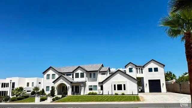 Modern white stucco exterior with black trim, a gabled roofline, and an arched entry