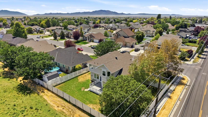 Aerial perspective highlighting the property's large backyard with a white privacy fence and a rear deck