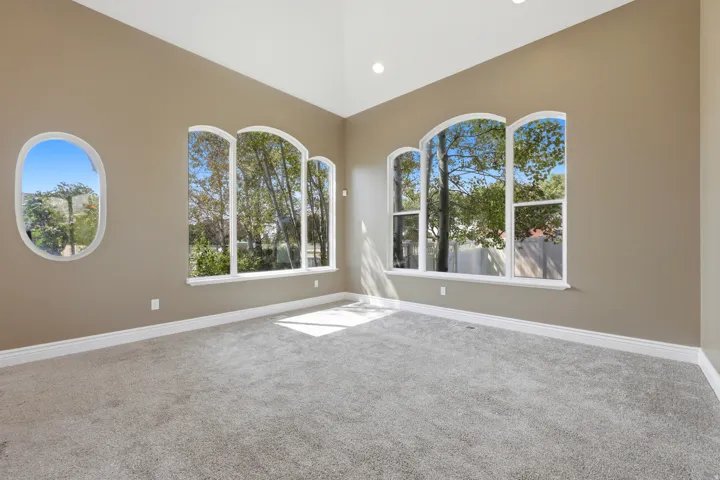 Vaulted ceilings highlighting multiple arched windows and a distinctive oval window
