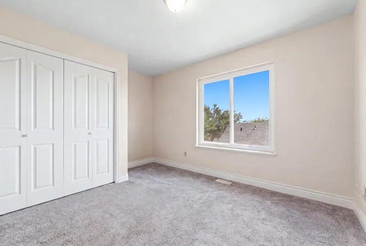 Bedroom featuring light-colored walls, gray carpeting, and white baseboards