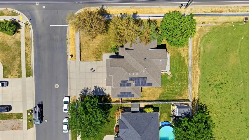 Aerial perspective of a property with a gray shingle roof and solar panels