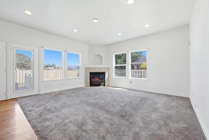 Living room with a corner fireplace featuring a tile surround and mantel niche