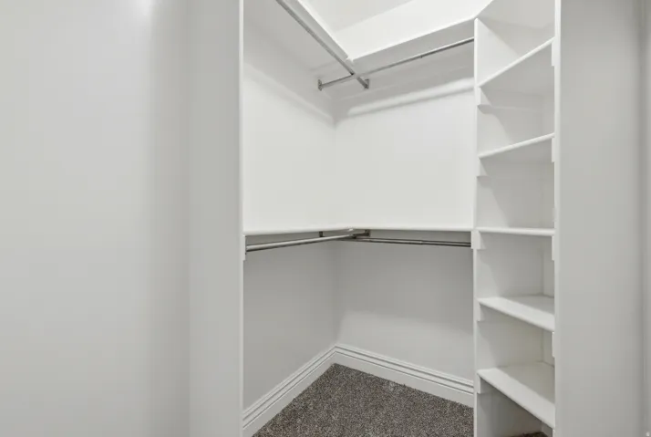 Organized closet system featuring multiple shelving units and dual hanging rods