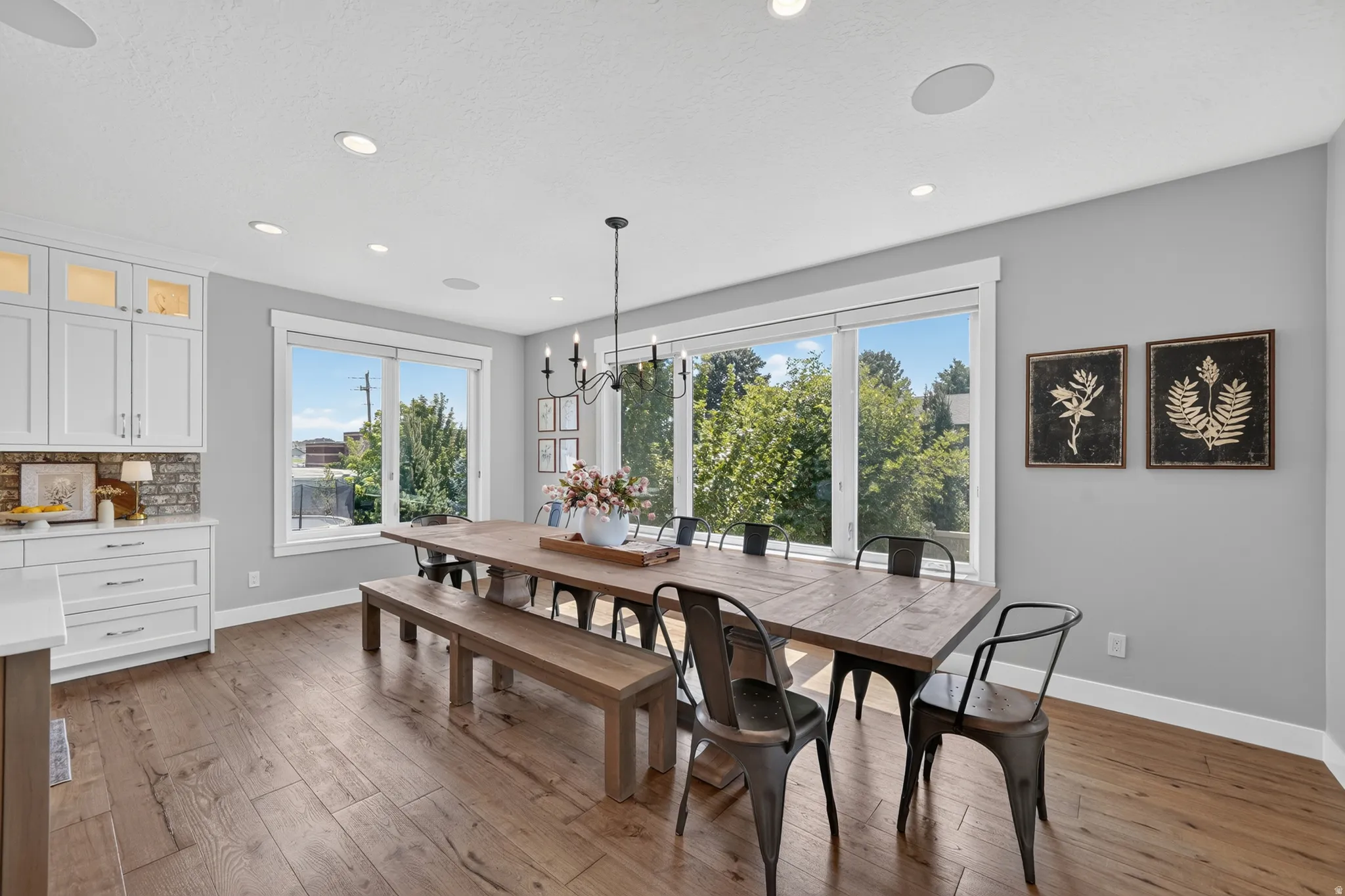 Spacious dining area featuring wood-finish flooring, recessed lighting, and a chandelier