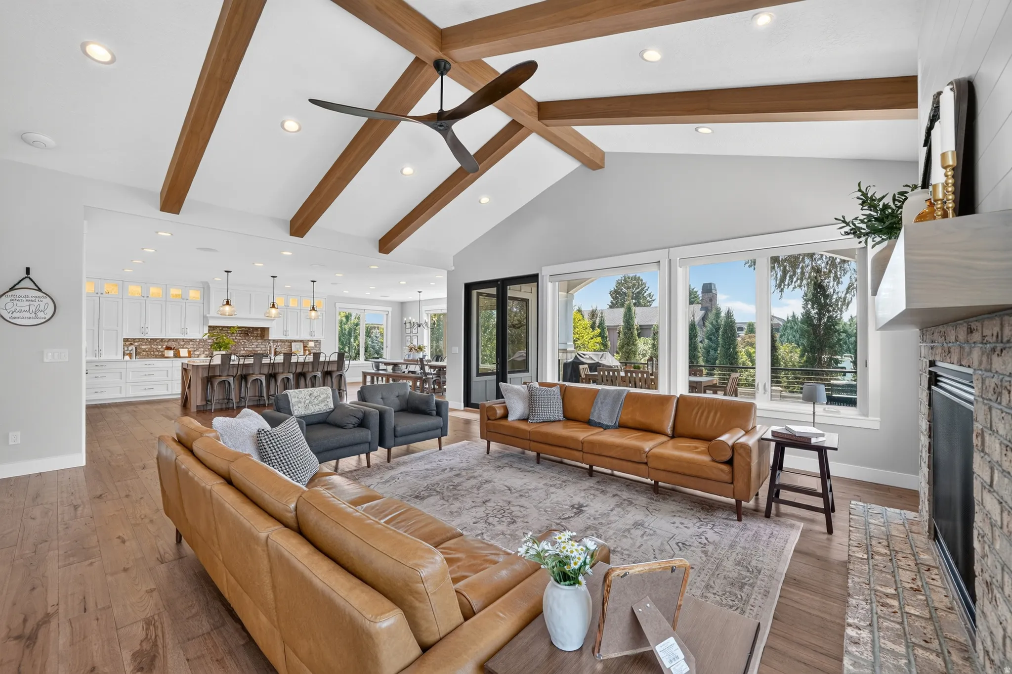 Spacious living area featuring a vaulted ceiling with exposed wood beams and recessed lighting