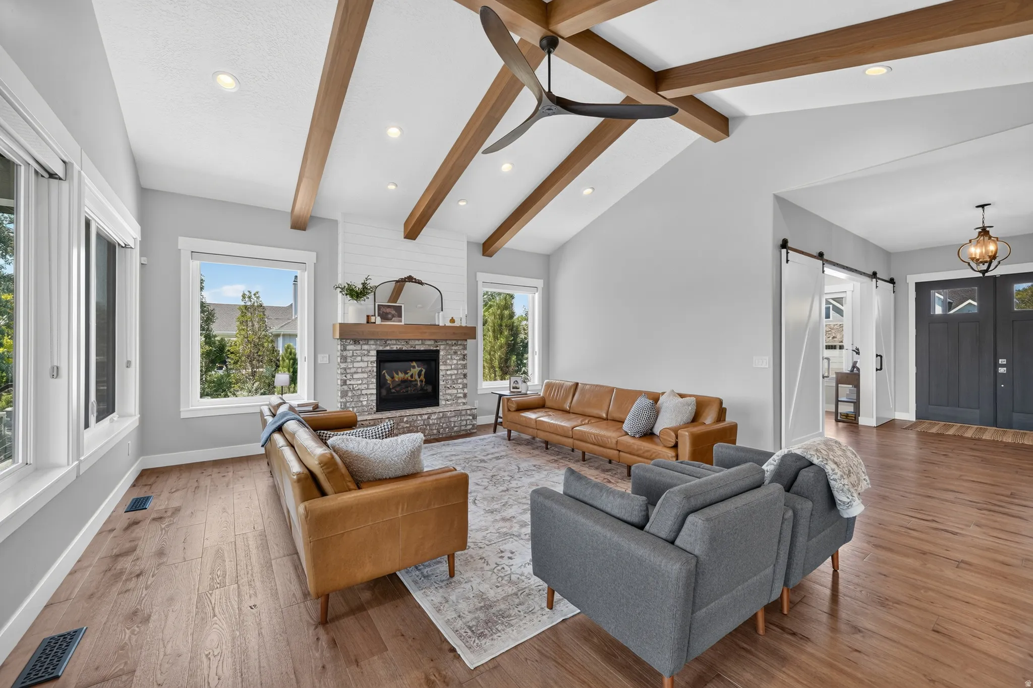 Vaulted ceiling with exposed wood-finish beams and a contemporary ceiling fan