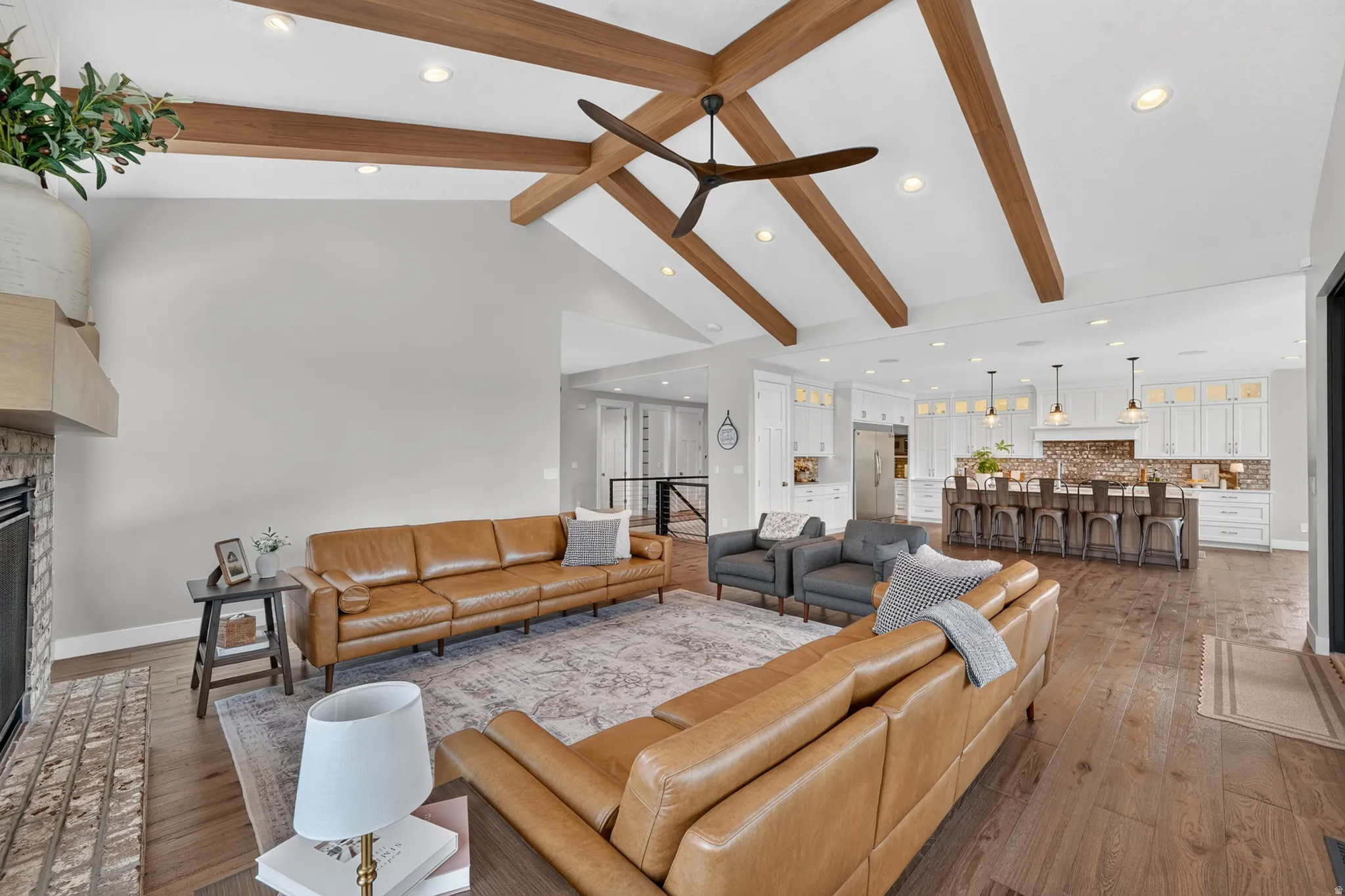 Vaulted ceilings with exposed wood beams and a contemporary ceiling fan