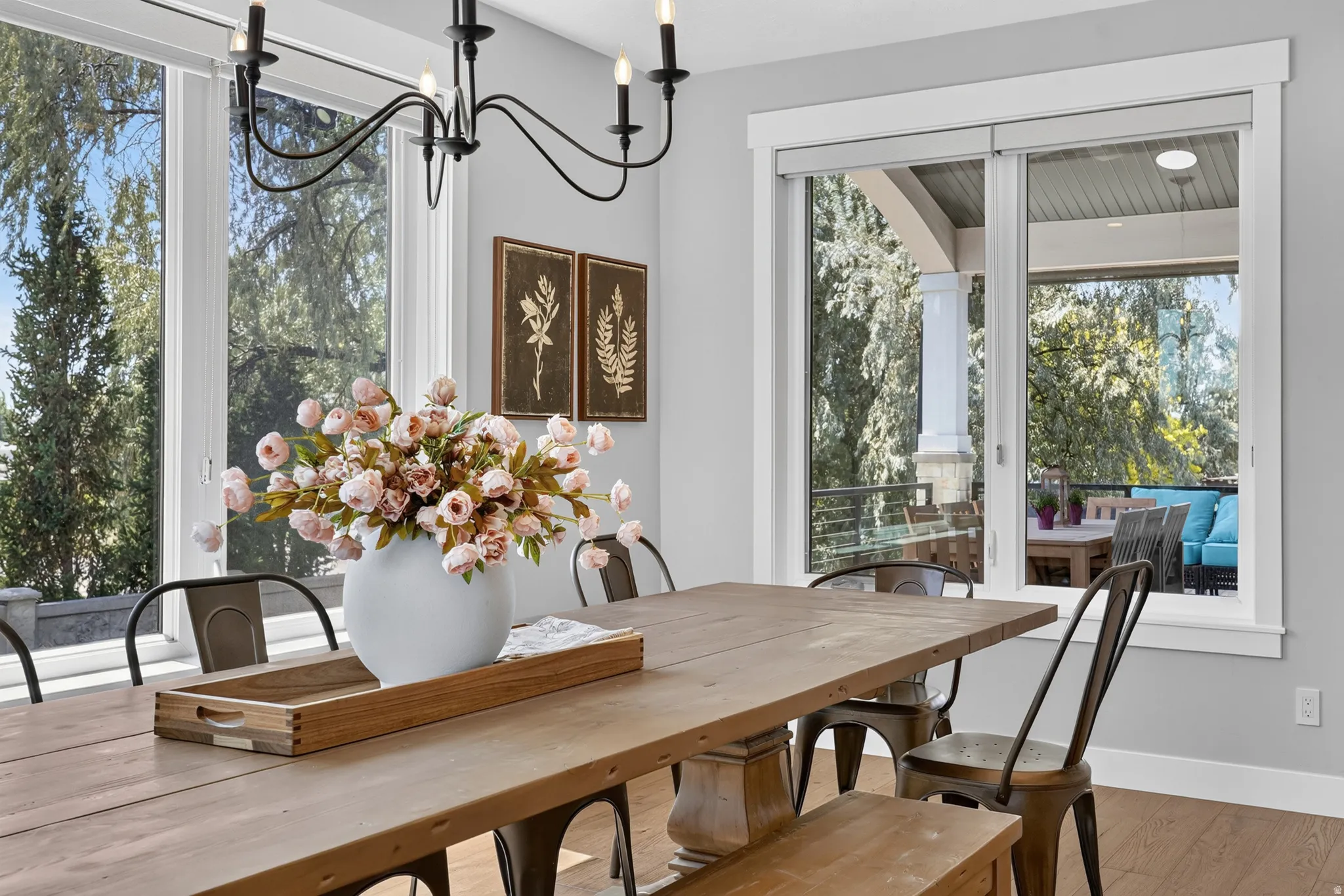 Dining area featuring a black metal chandelier, a substantial wood-finish dining table, and light gray wall paint