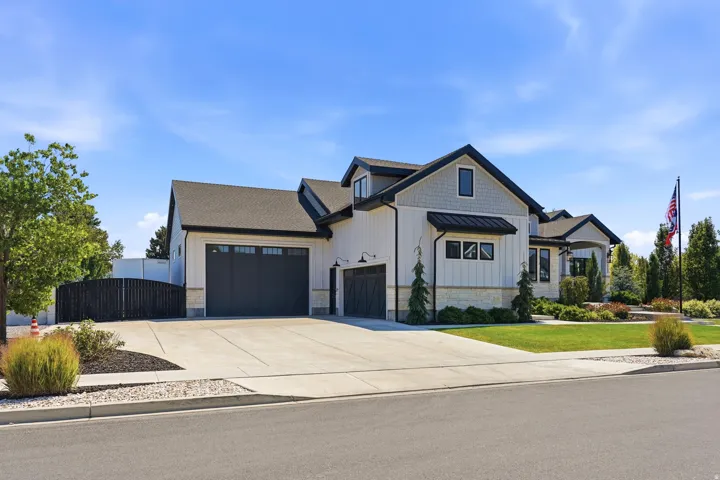 Contemporary exterior featuring white board and batten siding, dark trim, and a stone accent foundation