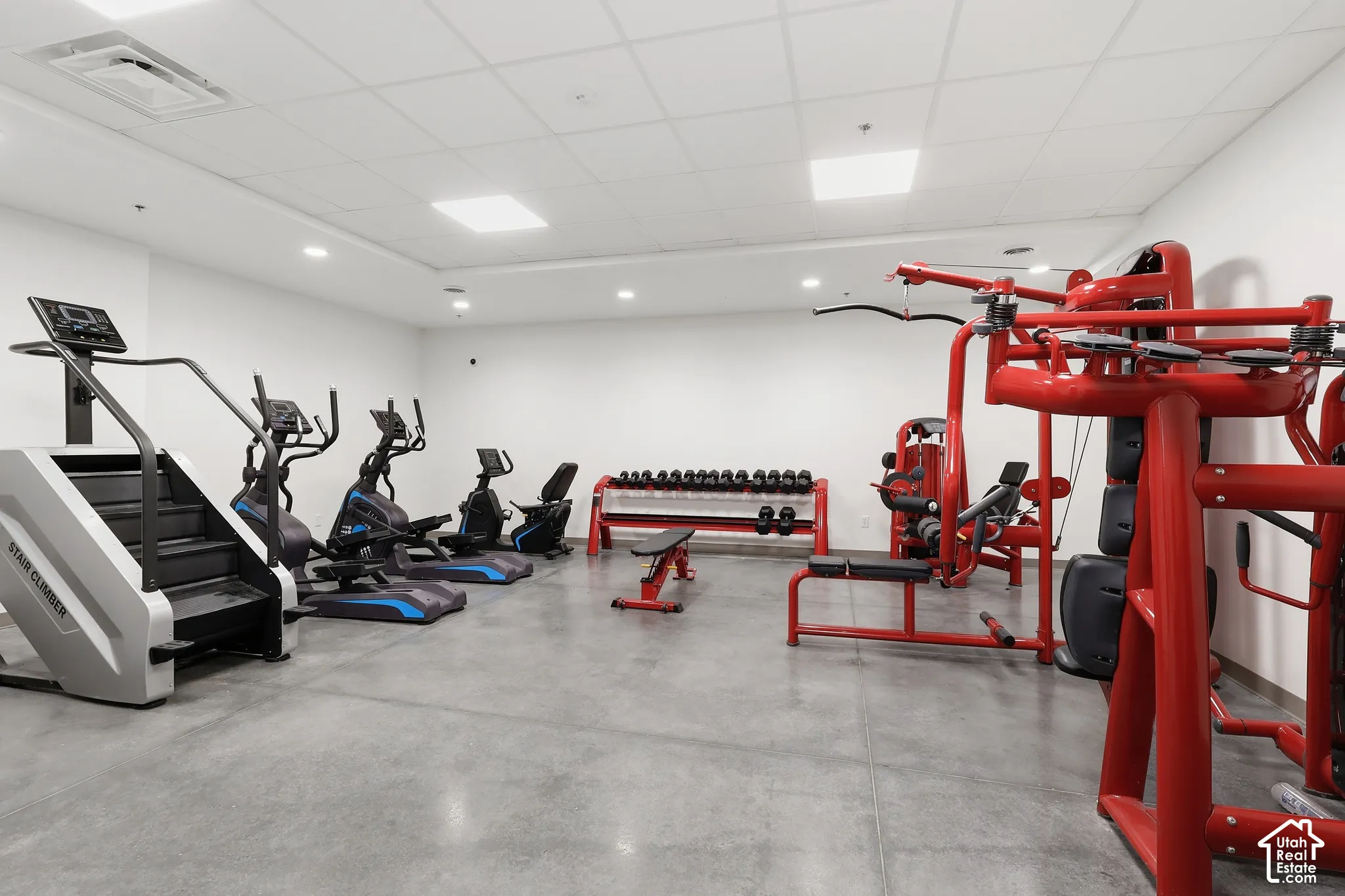 Dedicated fitness area featuring a concrete floor, recessed lighting, and white walls