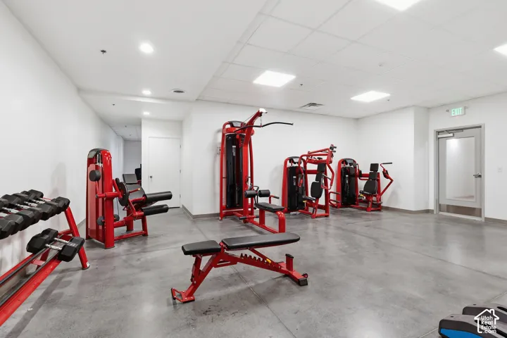 Fitness center featuring concrete flooring, white walls, recessed lighting, and gym equipment