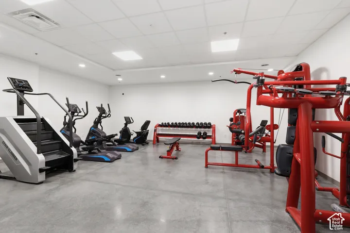 Dedicated fitness area featuring a concrete floor, recessed lighting, and white walls
