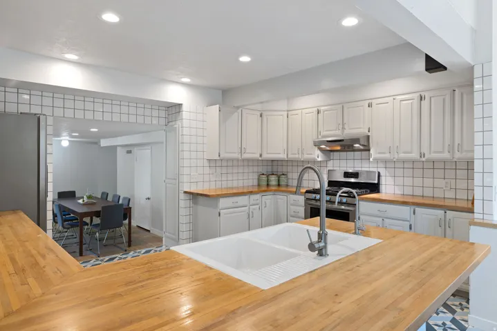 Kitchen featuring an island with a double basin sink and a gooseneck faucet