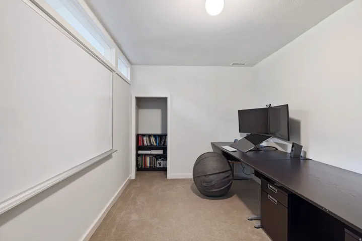 Dedicated room featuring transom windows, a built-in whiteboard, and neutral carpet flooring