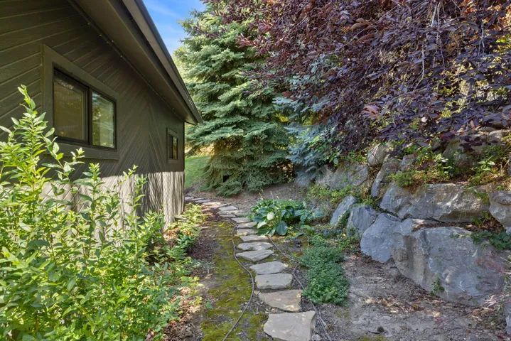 Stone pathway bordering a retaining wall with lush landscaping