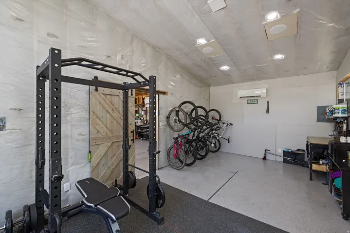 Versatile interior space featuring an exposed ceiling, recessed lighting, and a barn-style sliding door
