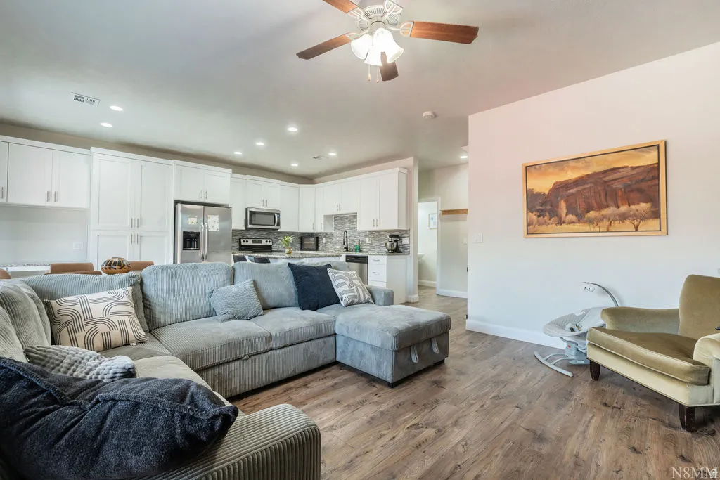 Open-concept living space featuring wood-finish flooring and recessed lighting
