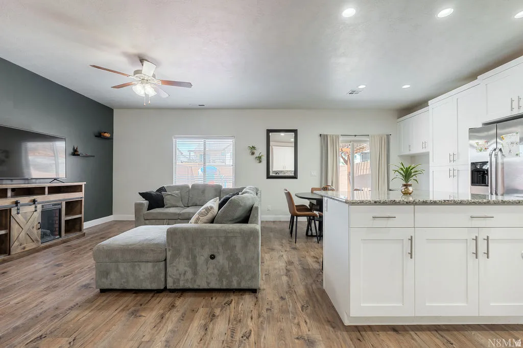 Open-concept living space featuring wood-finish flooring, recessed lighting, and a ceiling fan