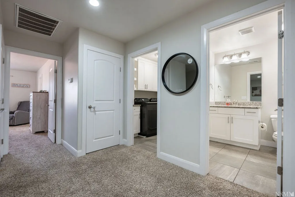 Hallway with neutral carpeting, white trim, and recessed lighting