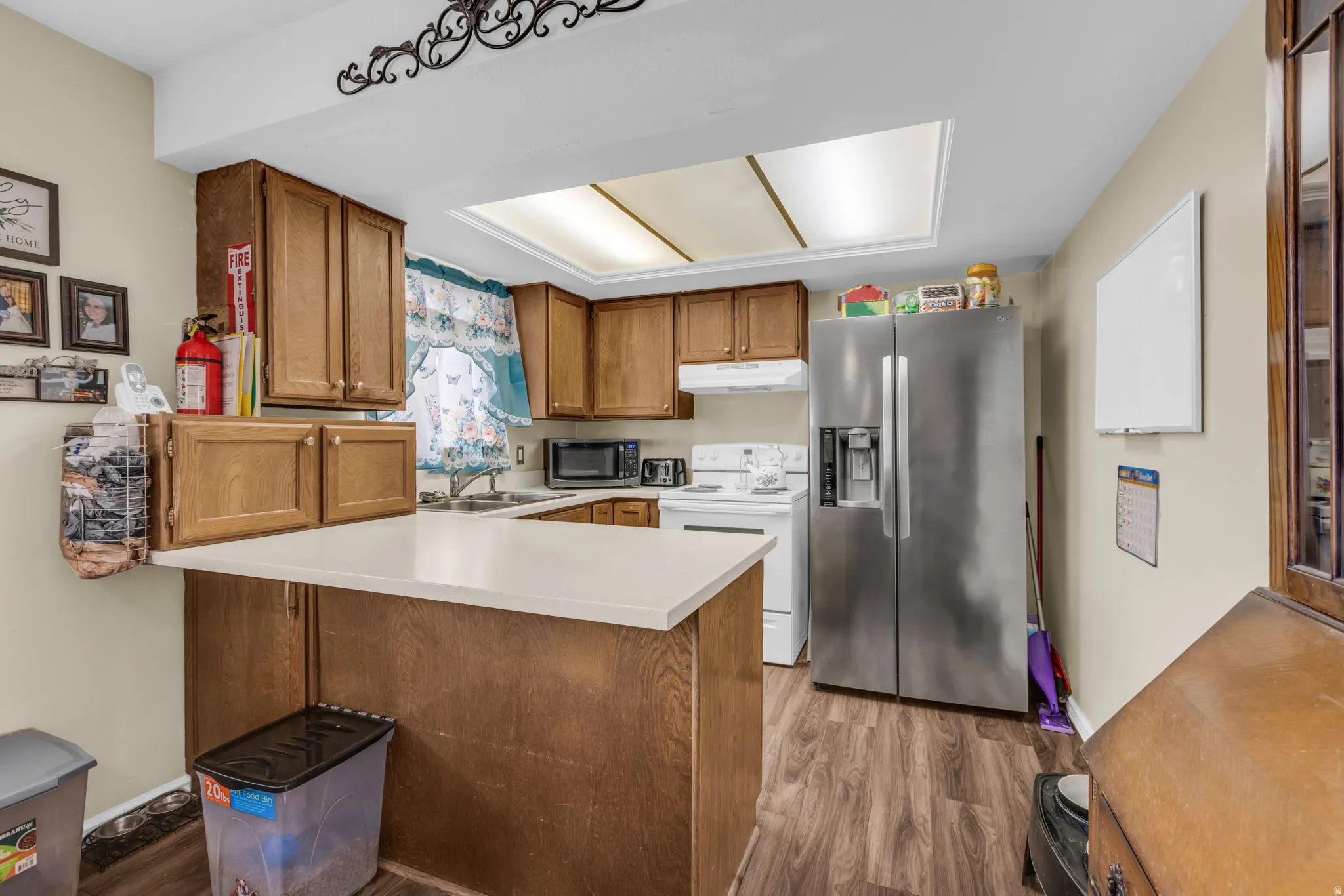 Kitchen featuring wood cabinetry, white countertops, wood-finish flooring, and a skylight