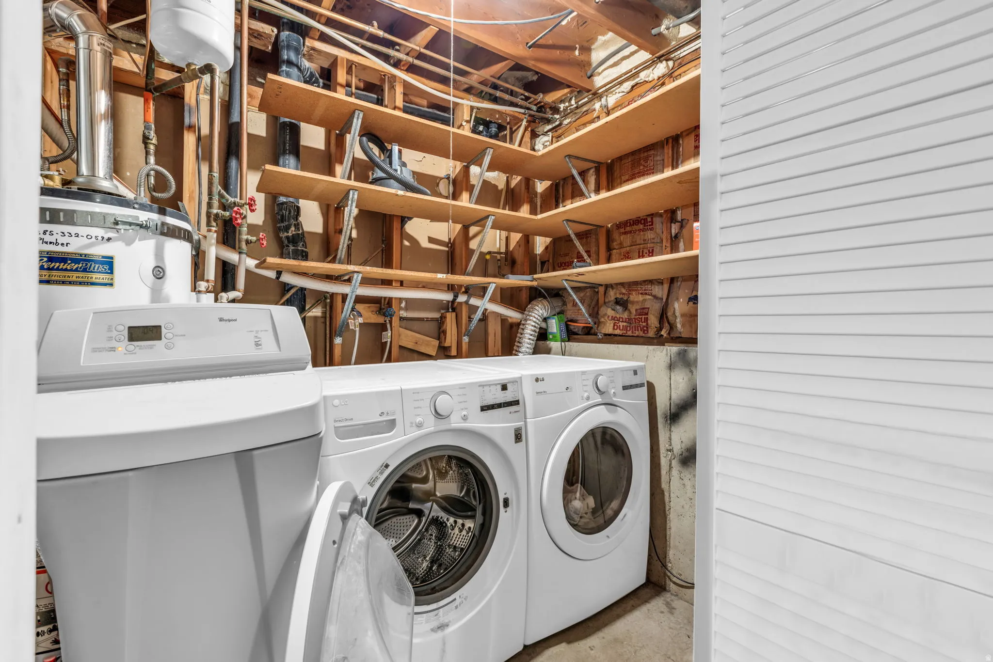 Dedicated utility space featuring a water heater, water softener system, and laundry appliances