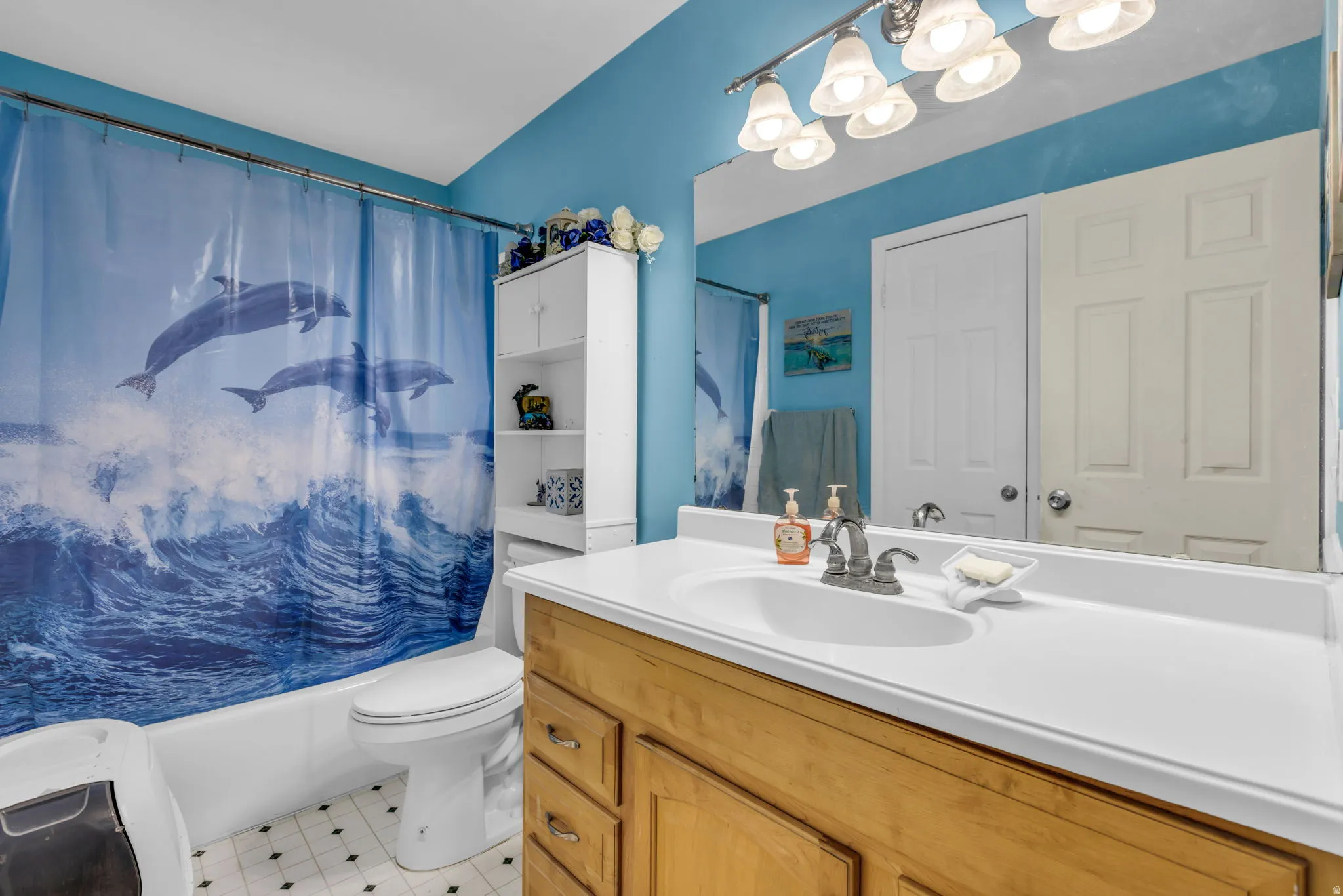 Bathroom featuring a light-toned wood vanity with a white countertop and integrated sink