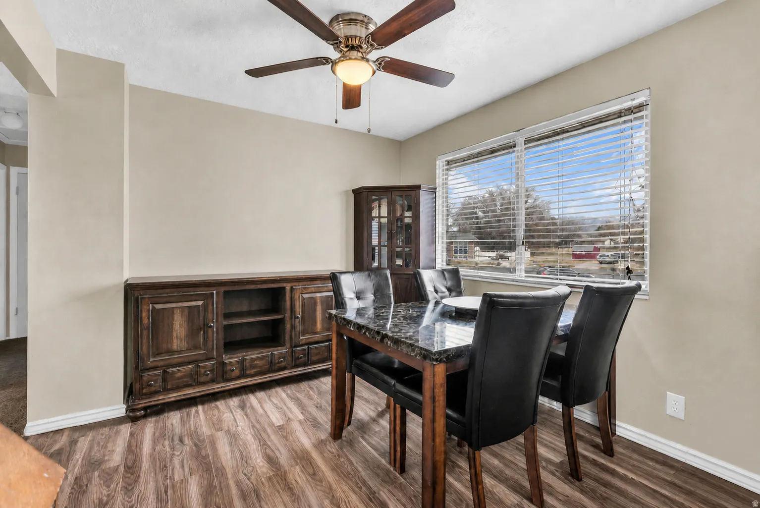 Wood-finish flooring with a ceiling fan overhead