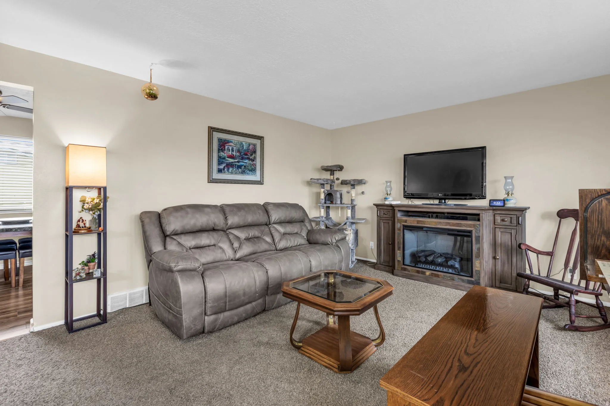 Living space featuring neutral wall tones and a textured carpet