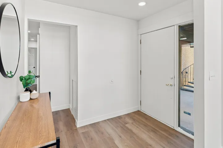 Entryway featuring wood-finish flooring, recessed lighting, and a solid entry door with a sidelight window