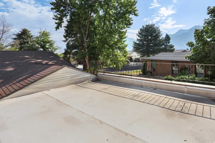 Expansive outdoor patio with metal railing and distant mountain scenery