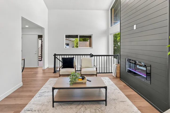 Vaulted ceilings complement the dark shiplap feature wall with an integrated linear electric fireplace