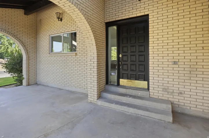 Entryway featuring light-colored brick exterior with an arched portico