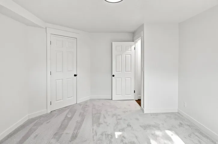 Light gray carpeting with white baseboards and trim