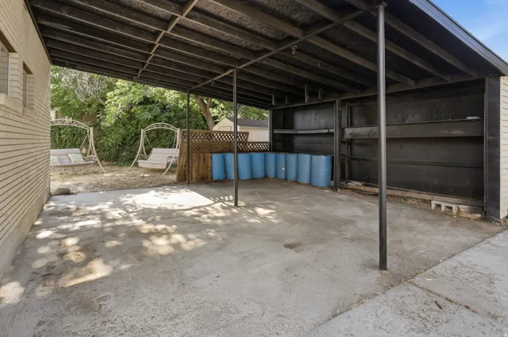 Covered concrete patio extending from a brick-clad structure