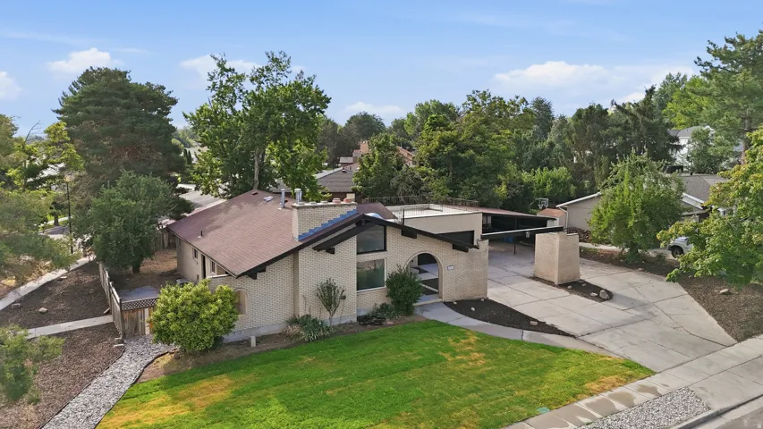 Contemporary residence featuring a light brick exterior and a brown shingled roof
